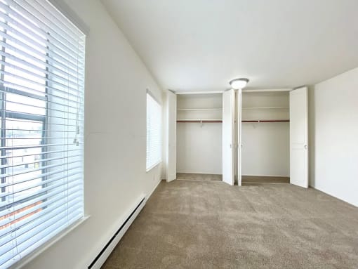 a bedroom with a large window and a closet