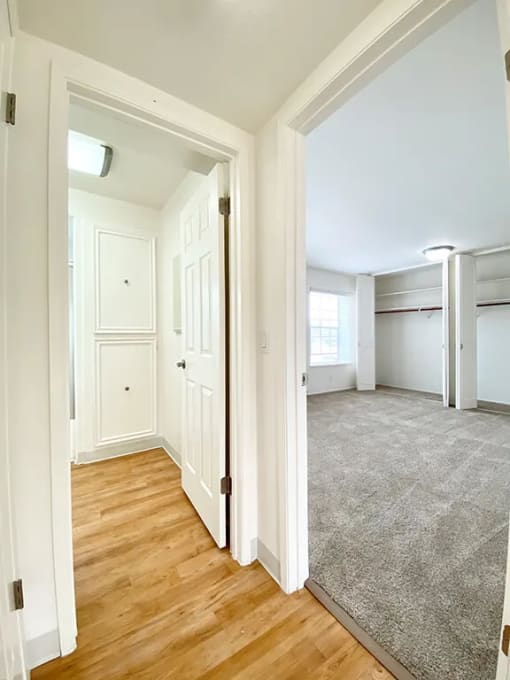 an empty room with white walls and wood floors