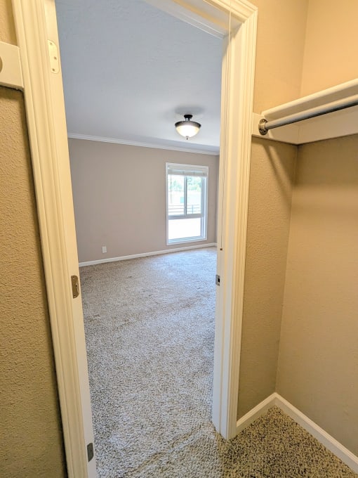 an empty bedroom with a closet and a window