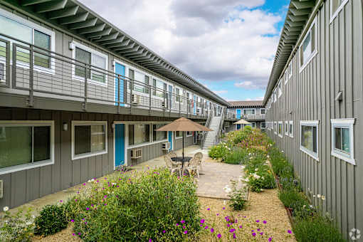 the courtyard is full of flowers and tables and chairs