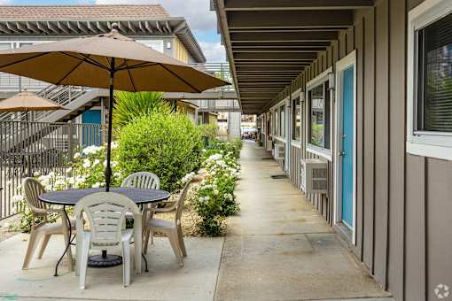 a patio with a table and chairs under an umbrella