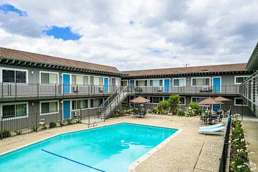 a swimming pool in front of a hotel with a pool