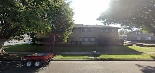 A red truck is parked on the street in front of a house.
