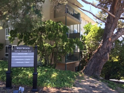 an apartment building with a sign in front of it