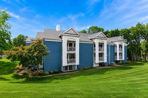 A blue house with white trim and a green lawn.