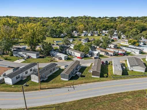 A road runs through a residential area with houses on both sides.