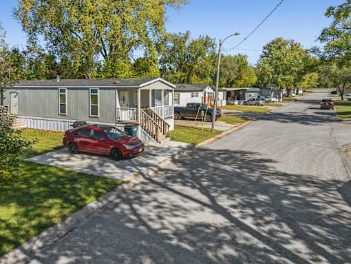 A red car is parked in front of a house.