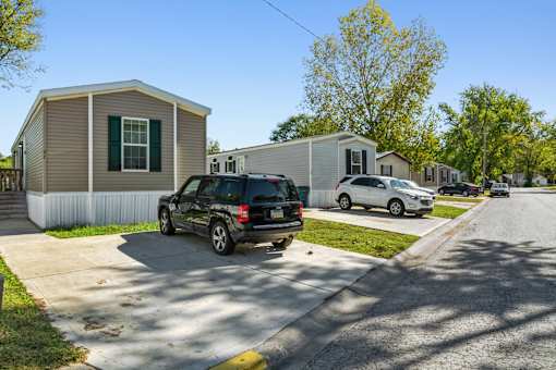 A black SUV is parked in front of a house.