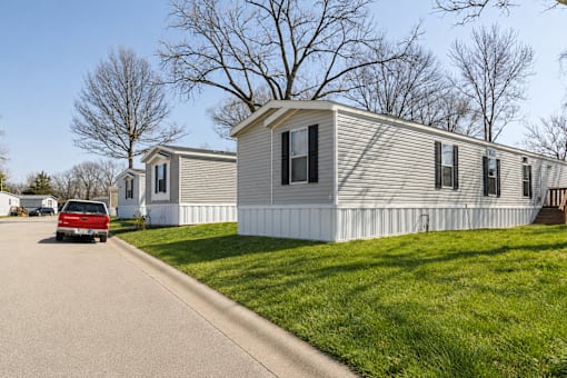 A red car is parked in front of a house.