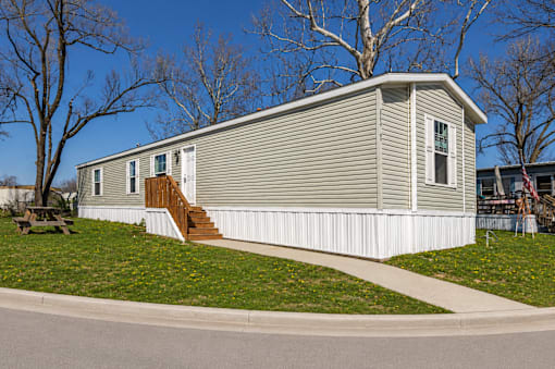 A small house with a grey roof and white siding.
