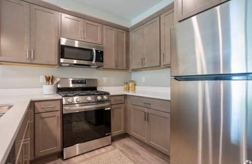 A kitchen with a stove, microwave, and refrigerator at Ventura Townhouses, West Olive  , 49460