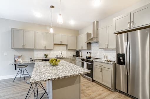 A kitchen with a granite countertop and stainless steel appliances.