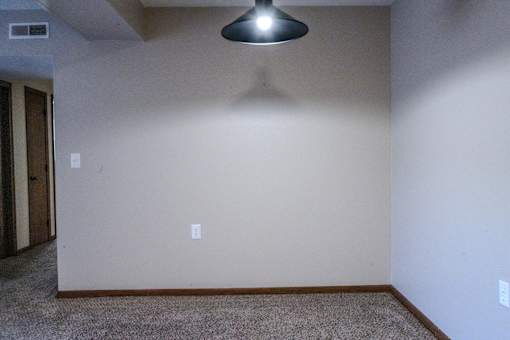 A room with a carpeted floor and a light fixture.