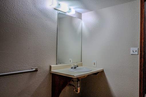 A bathroom sink under a mirror with a light above it.