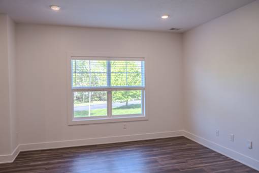 A room with a window and wooden floors.