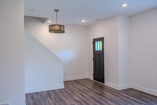 A room with a wooden floor and a black door.