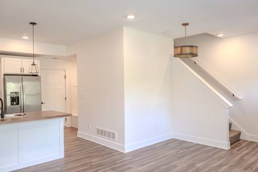A kitchen with white cabinets and a stainless steel refrigerator.