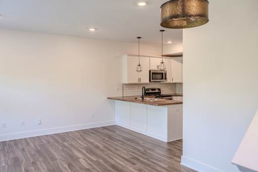 A kitchen with a white counter and a microwave on top.