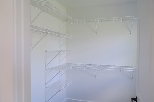Empty white shelves in a pantry.