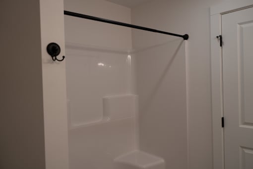A white bathroom with a glass shower door and a white toilet.