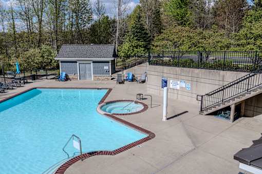 A pool with a slide and a small building in the background.