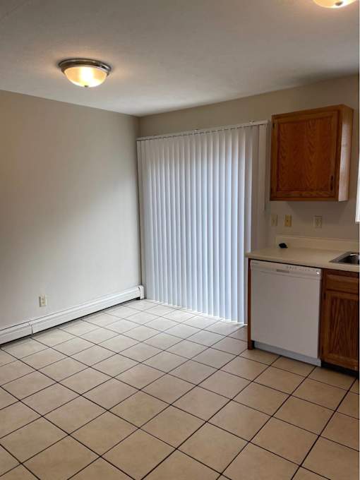A kitchen with white appliances and wooden cabinets.