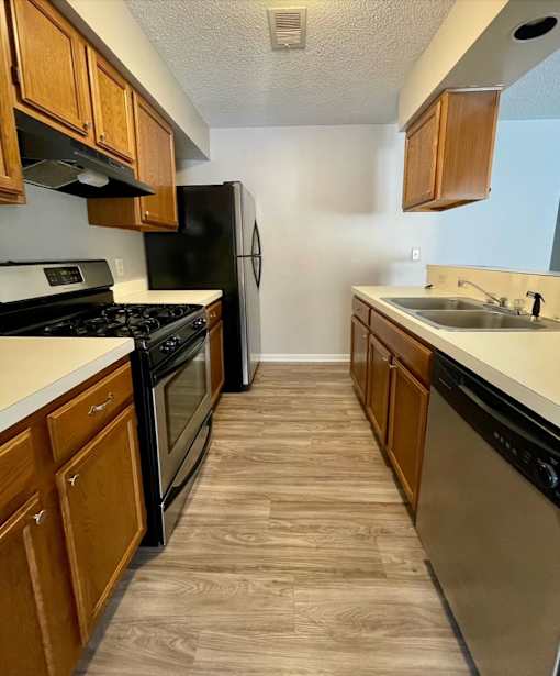 A kitchen with wooden cabinets and black appliances.