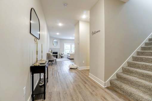 A hallway with a staircase and a mirror on the wall at Eden Forest Townhomes  Apartments, Kentwood , MI