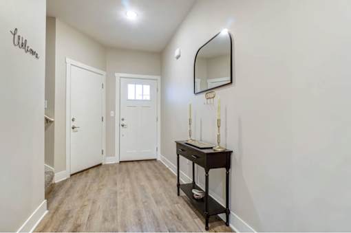 A hallway with a desk and a mirror on the wall at Eden Forest Townhomes Apartments, Kentwood 