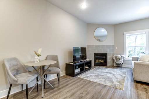 A living room with a fireplace and a television at Eden Forest Townhomes Apartments, Kentwood , Michigan