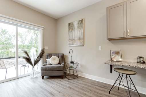 A living room with a grey couch, a small table, and a painting on the wall at Eden Forest Townhomes  Apartments, Kentwood , MI