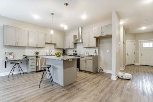 A kitchen with a white countertop and wooden floors at Eden Forest Townhomes Apartments, Michigan