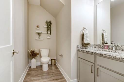 A white toilet sits in a bathroom with a wooden floor at Eden Forest Townhomes Apartments, Michigan, 49508