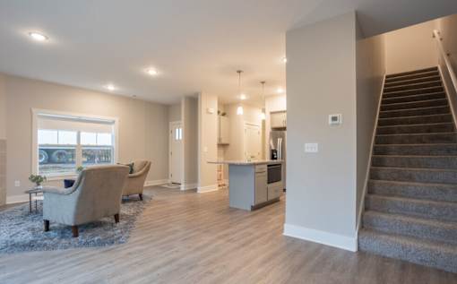 A living room with a staircase leading to the second floor at Eden Forest Townhomes Apartments, Michigan, 49508