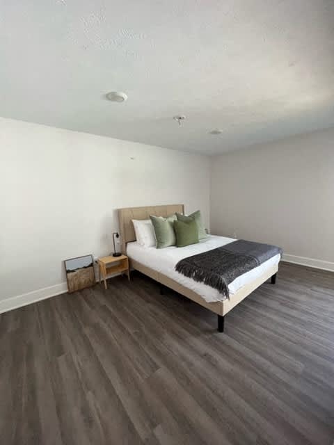 A bedroom with a bed, nightstand, and lamp at Michigan Street Apartment Homes, Grand Rapids  , Michigan