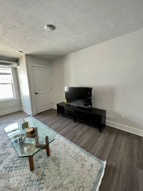 A living room with a glass coffee table and a black entertainment center at Michigan Street Apartment Homes, Grand Rapids  , Michigan