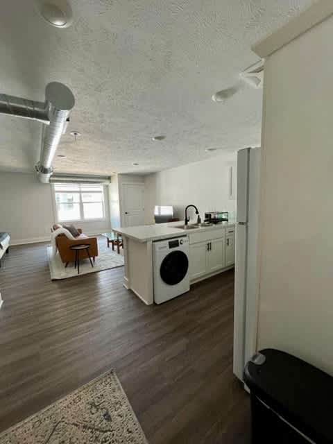 A room with a washing machine and a chair at Michigan Street Apartment Homes, Grand Rapids  