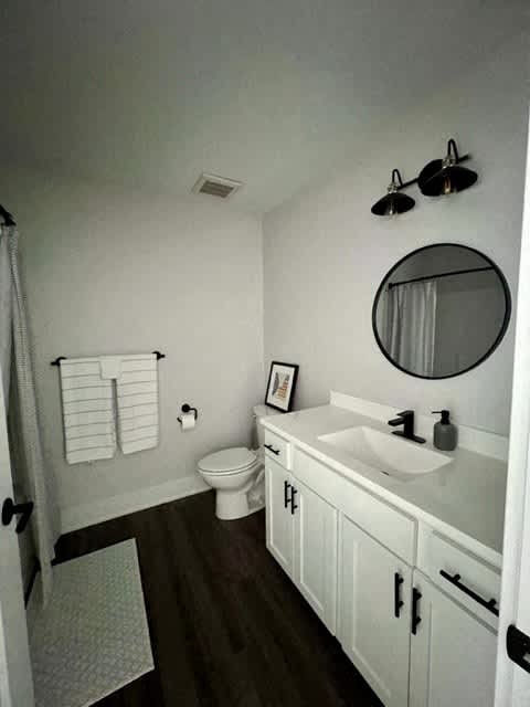 A bathroom with a toilet, sink, and mirror at Michigan Street Apartment Homes, Grand Rapids  , MI, 49503