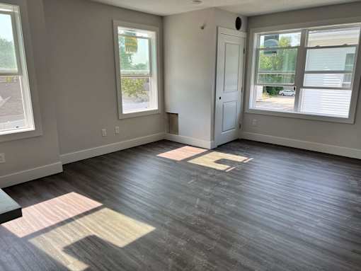 A room with wooden flooring and two windows  at Michigan Street Apartment Homes, Apartments, Grand Rapids  , MI