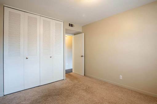 A room with a white door and a carpeted floor at Michigan Street Apartment Homes, Grand Rapids  