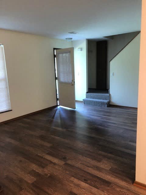 A room with wooden flooring and a staircase.