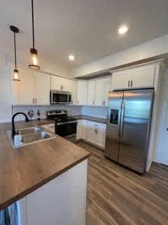 A kitchen with a stainless steel refrigerator and wooden countertops at The Vue at Rivertown Park Townhomes, Wyoming  , MI, 49418