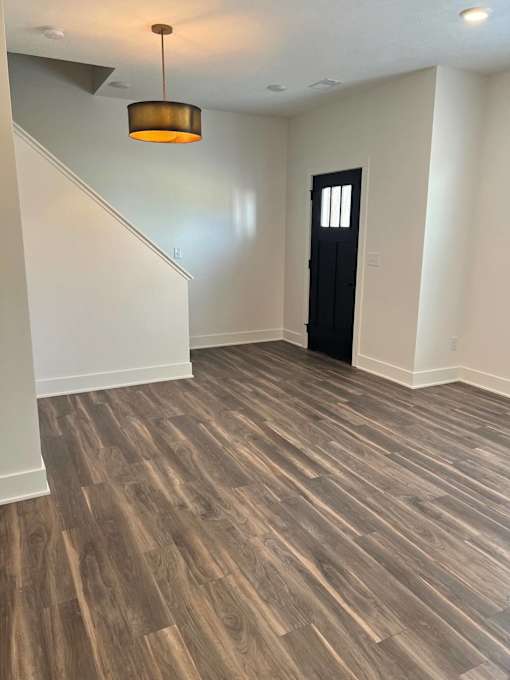 A room with a wooden floor and a black door at The Vue at Rivertown Park Townhomes, Michigan, 49418