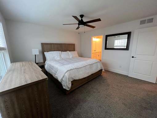 A bedroom with a bed, nightstand, and window at The Vue at Rivertown Park Townhomes, Michigan, 49418