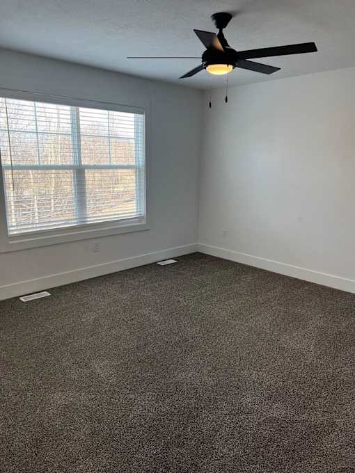 A room with a ceiling fan and a window with blinds at The Vue at Rivertown Park Townhomes, Wyoming  , 49418
