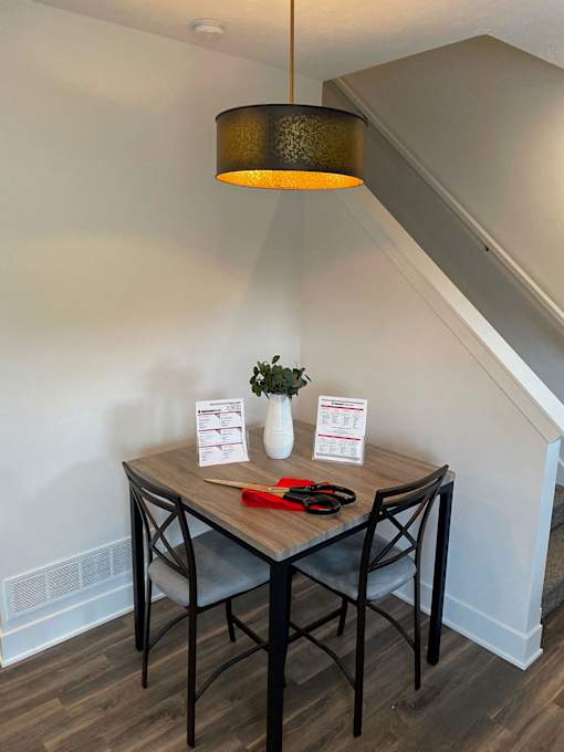 A table with a lamp and a vase with flowers on it at The Vue at Rivertown Park Townhomes, Wyoming  , 49418