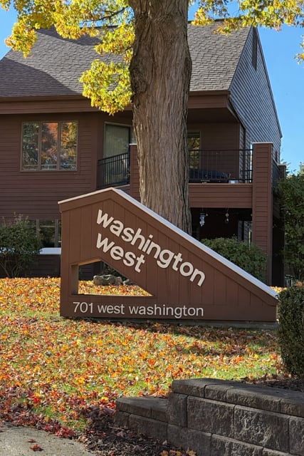 A sign that says Washington West stands in front of a house.