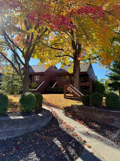 A house with a brown sign in front of it.