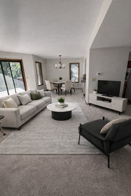 A modern living room with a grey carpet and white furniture.