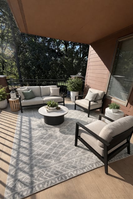 A patio with a couch, chairs, and a coffee table.